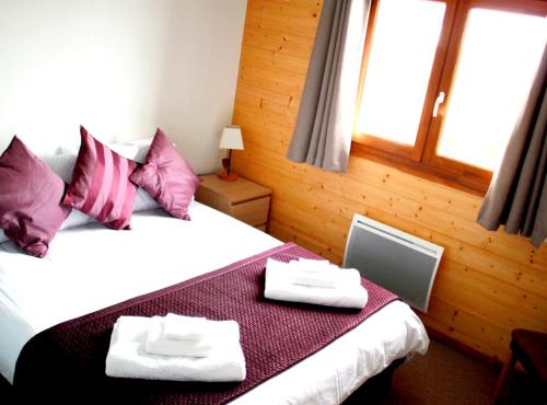 une chambre avec un lit avec deux serviettes dessus dans l'établissement Appartement confortable à Thollon-les-Mémises avec vue, à Thollon-les-Mémises