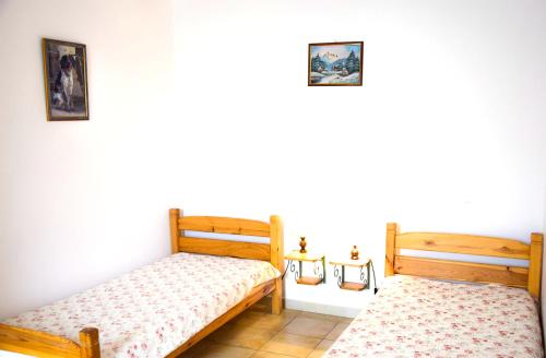 deux lits dans une chambre aux murs blancs dans l'établissement Appartement confortable à La Roche, 90 m² avec piscine partagée !, à La Roche-sur-le-Buis