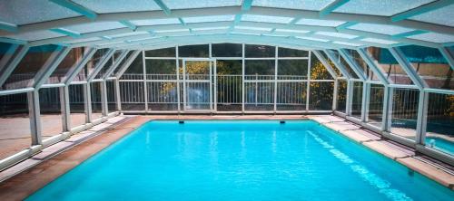 une piscine intérieure avec une grande paroi en verre dans l'établissement Appartement confortable à La Roche, 90 m² avec piscine partagée !, à La Roche-sur-le-Buis