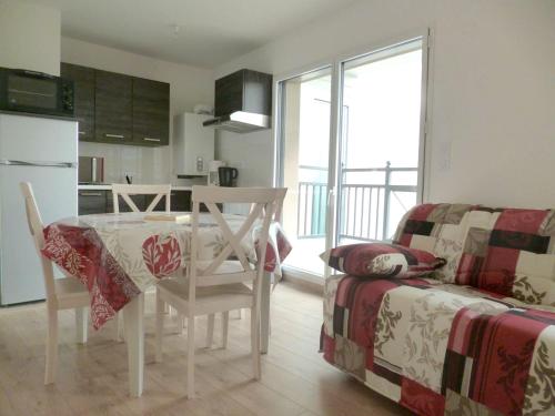 une cuisine et un salon avec une table et un canapé dans l'établissement Appartement charmant à Dinard avec balcon et jardin, à Dinard