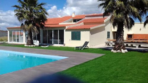 una casa con piscina y palmeras en 10 bedrooms villa with private pool enclosed garden and wifi at Palmela en Palmela