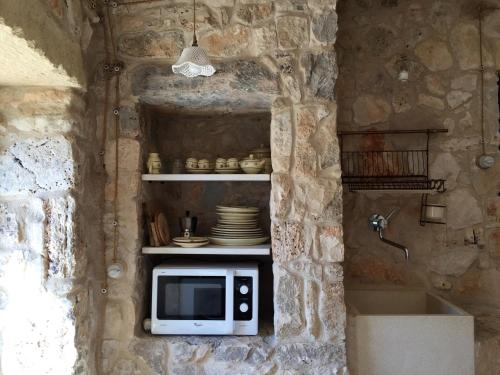 a kitchen with a microwave in a stone wall at Charming Apartment with Jacuzzi and Sea View - Salve, 85 sqm in Salve