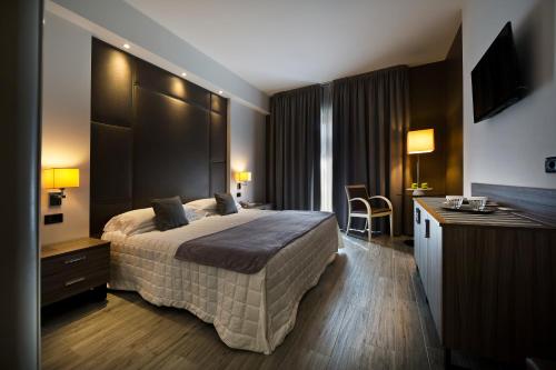 a hotel room with a bed and a desk at Hotel Desenzano in Desenzano del Garda