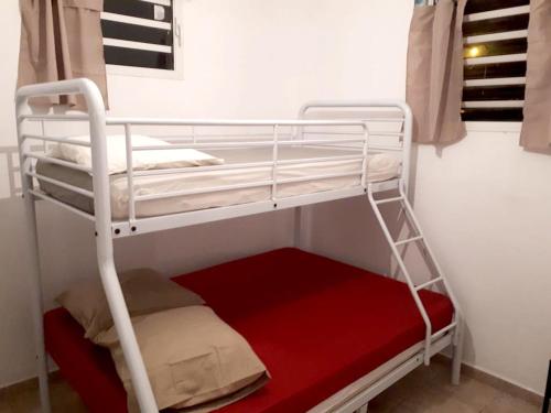 a bunk bed in a room with a red mattress at Maison de 2 chambres avec jardin clos a Morne A l'Eau a 2 km de la plage in Morne-à-lʼEau