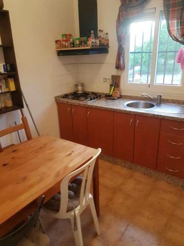 a kitchen with a wooden table and a sink at Cozy House Mountain View Algodonales in Algodonales