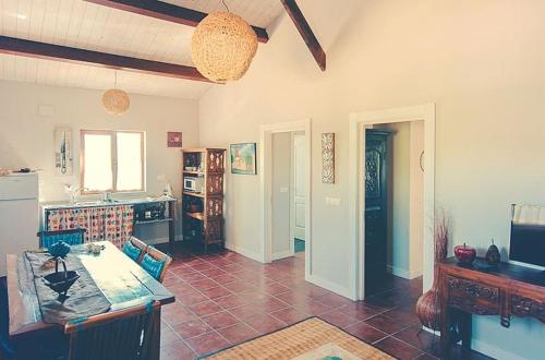 a living room with a kitchen with a counter top at 2 bedrooms house with shared pool furnished garden and wifi at Canamero in Cañamero