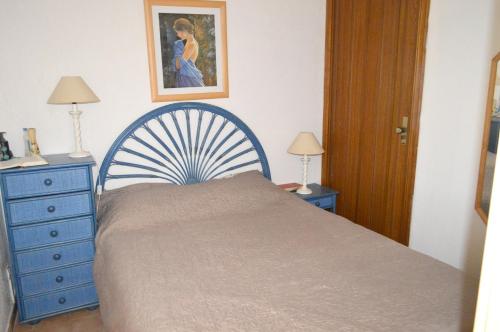 - une chambre avec un lit bleu et une commode bleue dans l'établissement Maison charmante à Gruissan avec piscine partagée, à Gruissan