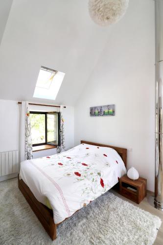 - une chambre blanche avec un grand lit fleuri dans l'établissement Maison confortable à Thégra avec grand jardin, idéale pour familles., à Thégra
