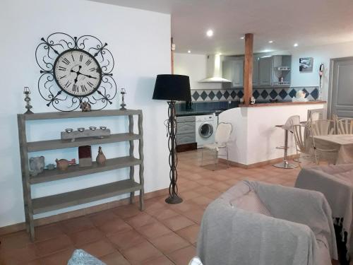 sala de estar con reloj en la pared en Maison charmante à Maillane avec piscine privée, en Maillane