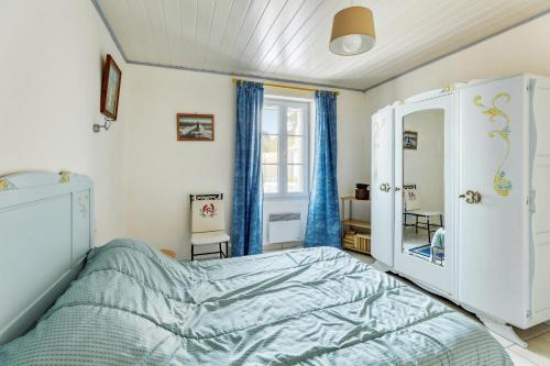 a bedroom with a bed and a mirror at Maison de 2 chambres a L'Epine a 700 m de la plage avec jardin clos et wifi in LʼÉpine