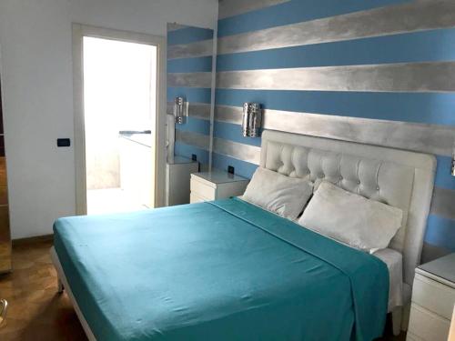 a bedroom with a blue and gray striped wall at One bedroom apartement with sea view jacuzzi and furnished terrace at Boca Chica in Boca Chica