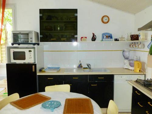 プルガヌーにあるMaison de charme à Plougasnou avec jardin clôturéのキッチン(テーブル、シンク、電子レンジ付)