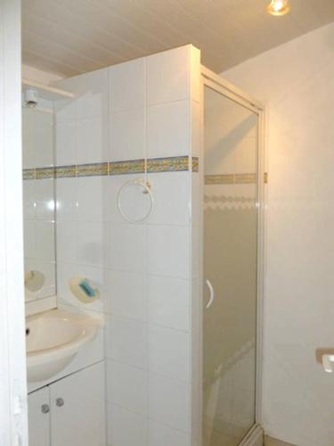 une salle de bain blanche avec une douche et un lavabo dans l'établissement Maison de charme à Plougasnou avec jardin clôturé, à Plougasnou
