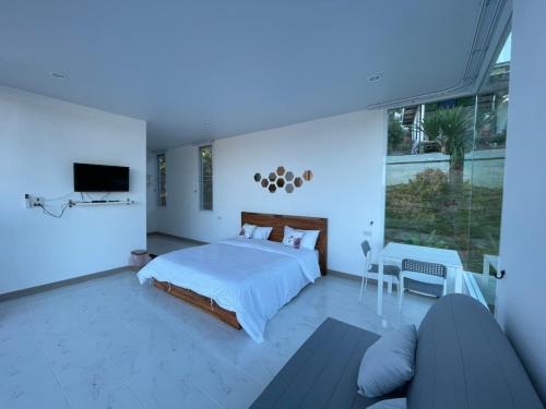 - une chambre avec un lit, une télévision et un canapé dans l'établissement Tawan Villa เขาค้อ, à Khao Kho