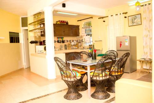 a kitchen with chairs and a table and a counter at Spacious apartment in Pereybere, 100 m² with shared pool in Pereybere