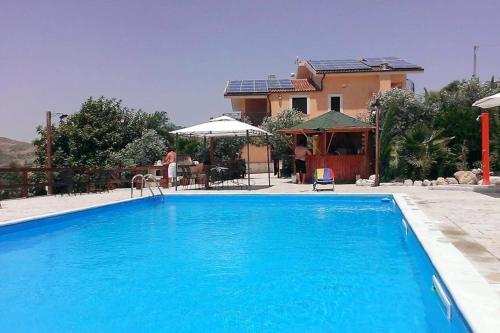 una grande piscina blu di fronte a una casa di 5 bedrooms villa with private pool furnished garden and wifi at Bompensiere a Bompensiere