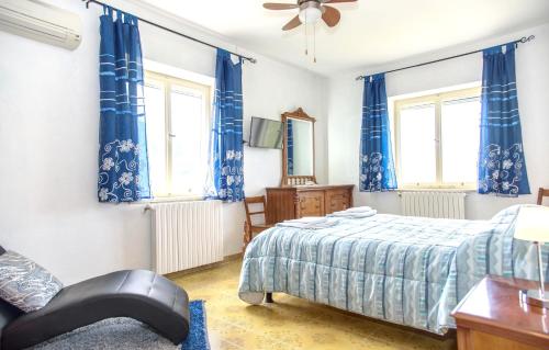 a bedroom with blue curtains and a bed and a chair at 2 bedrooms house with city view and wifi at Laurino in Laurino