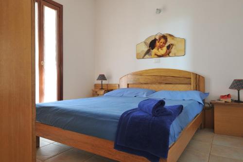 una camera da letto con un letto con una coperta blu sopra di 2 bedrooms apartement at santa Maria Navarrese Baunei 500 m away from the beach with wifi a Santa Maria Navarrese