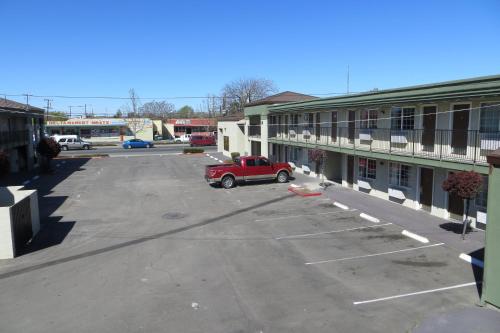 a red truck parked in a parking lot next to a building at American Inn Stockton in Stockton