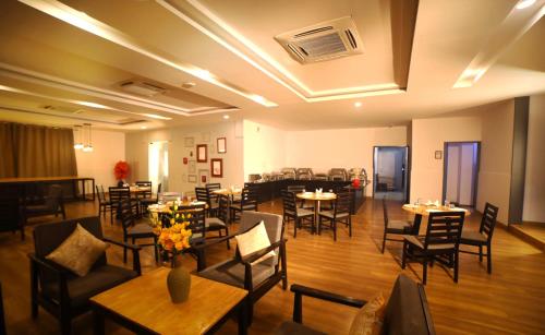 uma sala de jantar com mesas e cadeiras e uma sala com mesas e cadeiras em The Urban Stays em Hyderabad