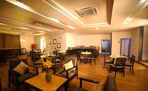 a dining room with tables and chairs and a room with tables and chairs at The Urban Stays in Hyderabad