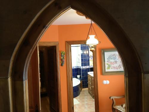 ナバレドンダ・デ・グレドスにある4 bedrooms house with enclosed garden and wifi at Navarredonda de Gredosのオレンジ色の壁のバスルームへのアーチ型の出入口