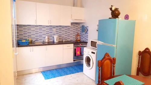 a kitchen with a refrigerator and a washing machine at 3 bedrooms house with furnished terrace and wifi at Ponta Delgada in Ponta Delgada