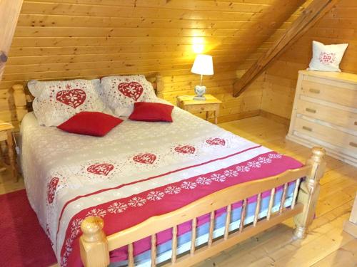 een slaapkamer met een bed met rode en witte kussens bij Chalet de 4 chambres avec jardin amenage a Lalaye in Lalaye