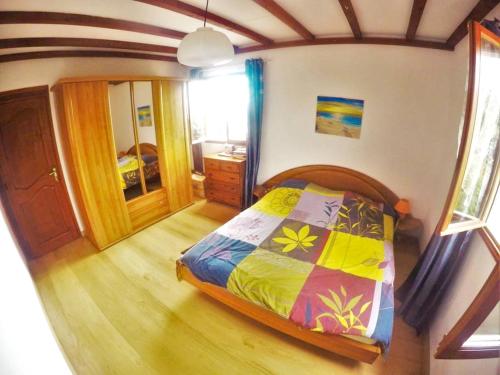 1 dormitorio con 1 cama con un edredón colorido en Appartement de 3 chambres avec vue sur la mer jardin clos et wifi a Le Tampon a 8 km de la plage, en Le Tampon