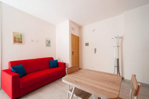a living room with a red couch and a wooden table at Romantic Apartment in Vieste - 40 m² with Sea View in Vieste