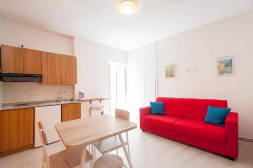 a living room with a red couch and a table at Romantic Apartment in Vieste - 40 m² with Sea View in Vieste