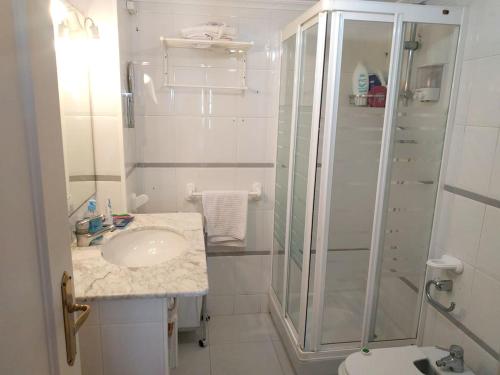 ein weißes Badezimmer mit Dusche und Waschbecken in der Unterkunft Spacious house in Roquetas de Mar, 140 m², shared pool in Roquetas de Mar