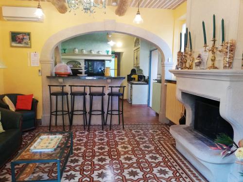 a living room with a fireplace and a kitchen at Maison charmante au Thor + Piscine in Le Thor