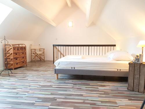 une chambre avec un lit dans un grenier dans l'établissement Appartement lumineux à Sainte-Geneviève, 45 m² jardin, à Sainte-Geneviève-lès-Gasny