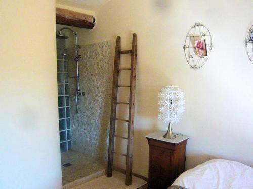 - une chambre avec une douche et une table avec une lampe dans l'établissement Maison de charme en campagne à Cucuron avec piscine privée, à Cucuron