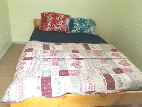 a bed in a room with a quilt on it at Charmant bungalow à Hell-Bourg avec vue sur montagnes et jardin in Hell-Bourg