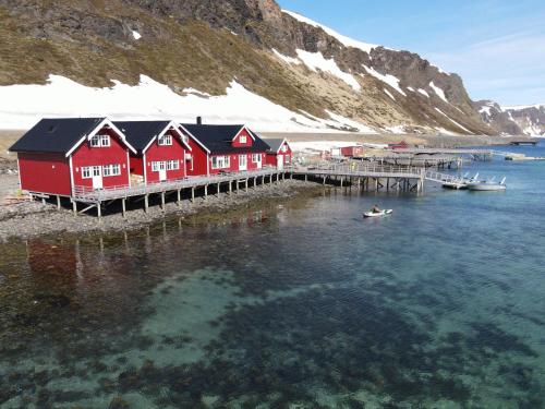 a row of boats sitting on top of a body of water at Sarnes Seaside Cabins in Honningsvåg