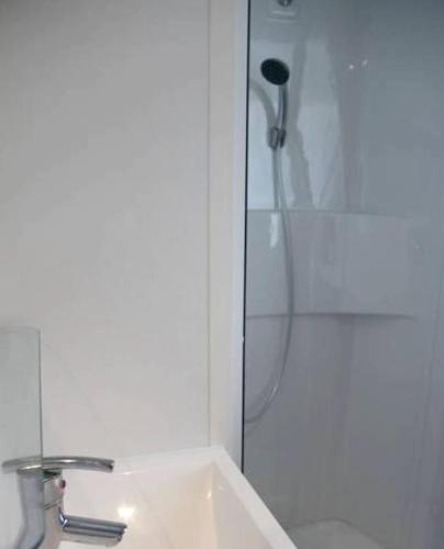 La salle de bains est pourvue d'une douche et d'un lavabo blanc. dans l'établissement Mobil-home moderne à Saint-Jean-de-Monts avec piscine partagée, à Saint-Jean-de-Monts