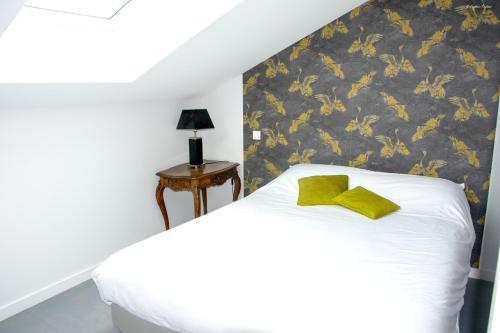 Un dormitorio con una cama blanca con una pajarita amarilla. en Villa élégante à Panissières avec piscine privée, en Panissières
