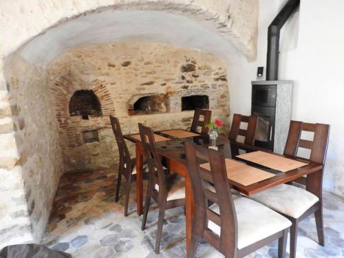 comedor con mesa y chimenea de piedra en Maison de 2 chambres avec wifi a Chalo Saint Mars, en Châlo-Saint-Mars