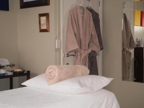 a bedroom with a bed with a towel hanging on the wall at Ribbonwood Country House in Cheviot