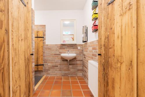 a bathroom with a sink and a brick wall at Lodge an der Eider - Stuuv tein in Friedrichsgraben