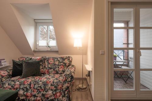 ein Wohnzimmer mit einem Sofa und einem Fenster in der Unterkunft Dat lütte Huus - Wohnung 1 in Husum