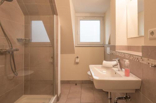 ein Bad mit einem Waschbecken, einer Dusche und einem WC in der Unterkunft Dat lütte Huus - Wohnung 1 in Husum