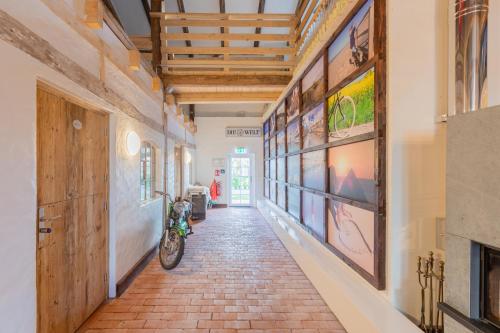 a hallway with paintings on the walls and a motorcycle parked at Lodge an der Eider in Friedrichsgraben