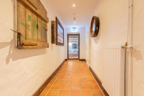 a hallway with an orange tile floor and a door at Lodge an der Eider in Friedrichsgraben
