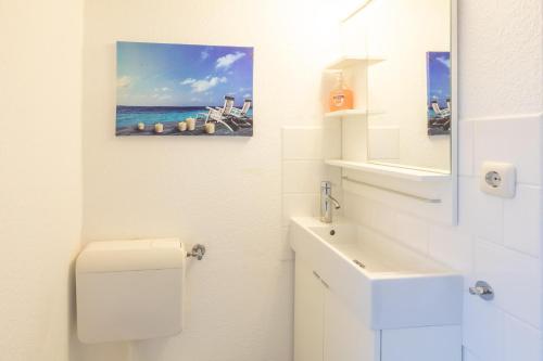 a bathroom with a sink and a picture of the ocean at Apartmenthaus Tönning Kleine Kajüte in Tönning
