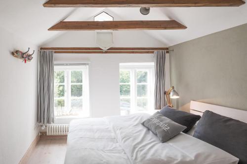 a bedroom with a white bed and a window at Beach-Loft in Wobbenbüll