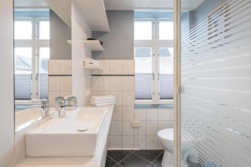 フーズムにあるApartmenthaus Theodor Storm Meeresstrandの白いバスルーム(洗面台、トイレ付)