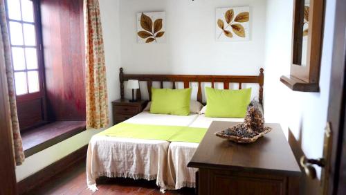 a bedroom with a bed with green pillows and a table at 2 bedrooms appartement with furnished terrace and wifi at Santa Cruz de Tenerife Canarias 5 km away from the beach in Los Silos